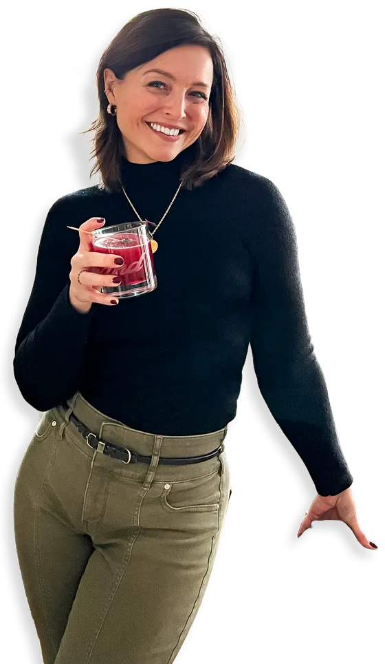 Piper G. Youtzy, smiling in a black turtleneck, cocktail in hand